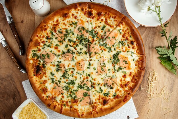 ソーセージグリーンとパルメザンチーズのトップビューのピザ