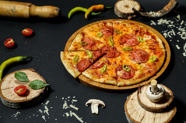 Pizza with sausages topped with pepper