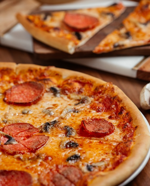 Pizza with slices of pepperoni and black olives