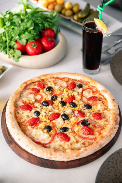 Pizza with tomatoes olives corn and bell peppers