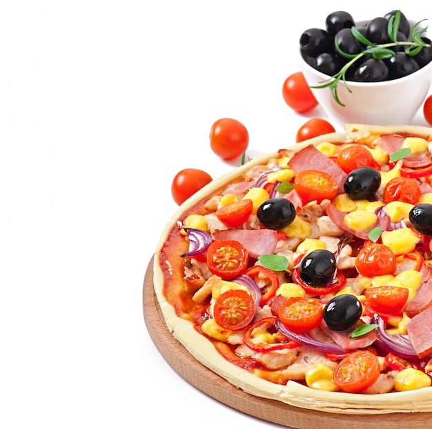 Pizza with vegetables, chicken, ham and olives isolated on white