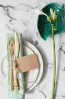 Free photo place setting with white plates; folded napkin and cutlery with white flowers