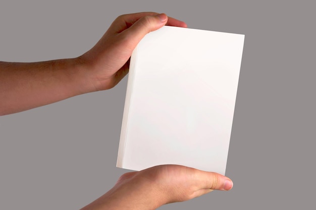 Free photo plain white book holded on a light background