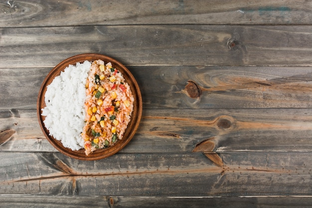 Free photo plain white and chinese fried rice on wooden plate over the table