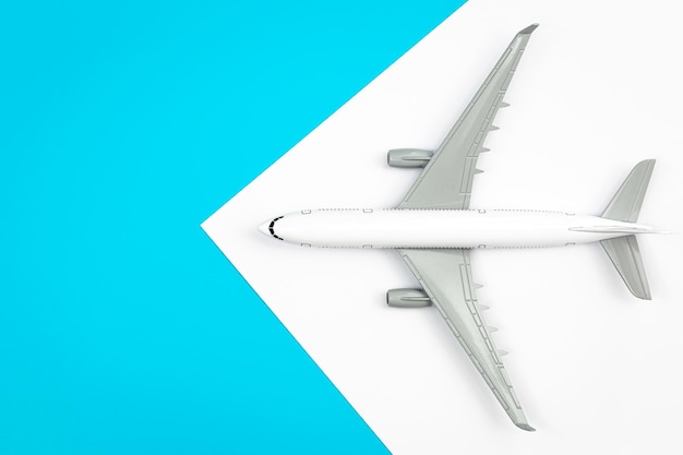 Free photo a plane airplane on a blue background flat lay copy space