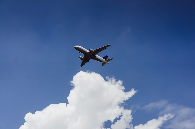 the plane is flying in the blue sky