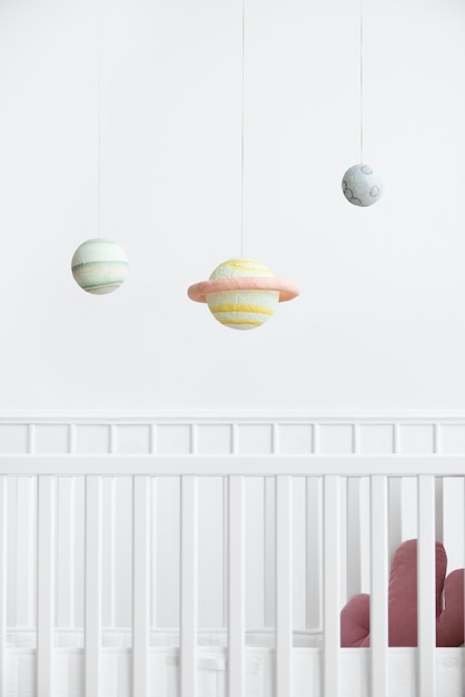 Planetary mobile above a white crib