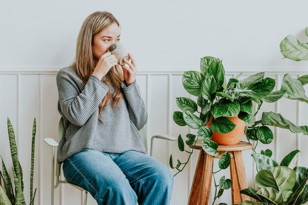 Plant lady resting and sipping tea in her plant corner