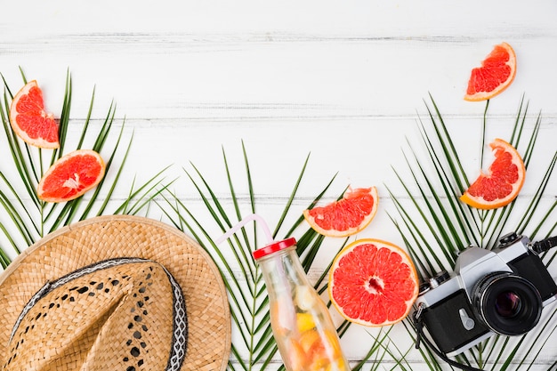 Plant leaves near citruses and hat with camera