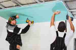 Free photo plasterboard installers. men assembling a drywall false ceiling.simple and affordable renovation of premises