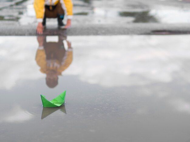 Plastic boat and boy in raincoat