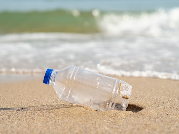 Foto gratuita bottiglia di plastica lasciata sulla spiaggia