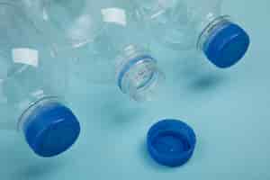 Foto gratuita bottiglie di plastica su sfondo blu ad angolo alto