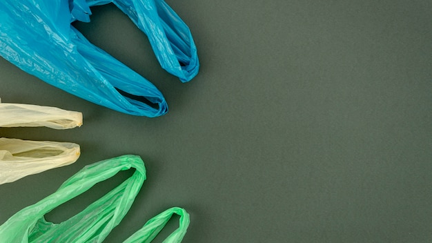 Free photo plastic colorful bags arranged on gray background