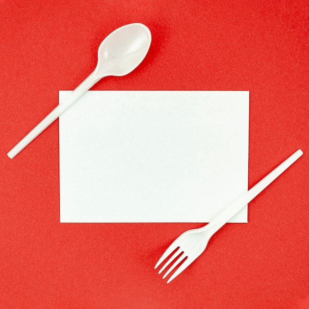 Plastic cutlery for picnics on red background