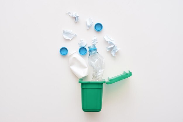 Plastic garbage from milk and water are falling into recycled bin isolated