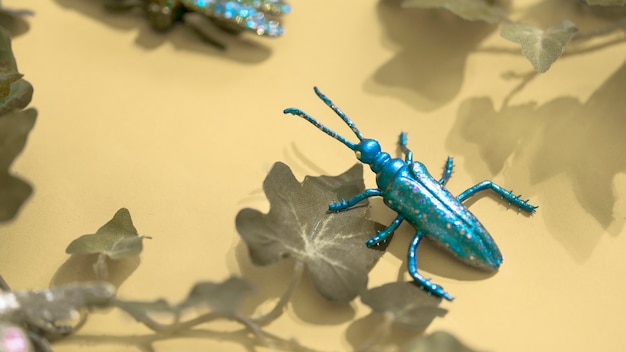 Foto gratuita insetto di plastica tra le foglie verdi