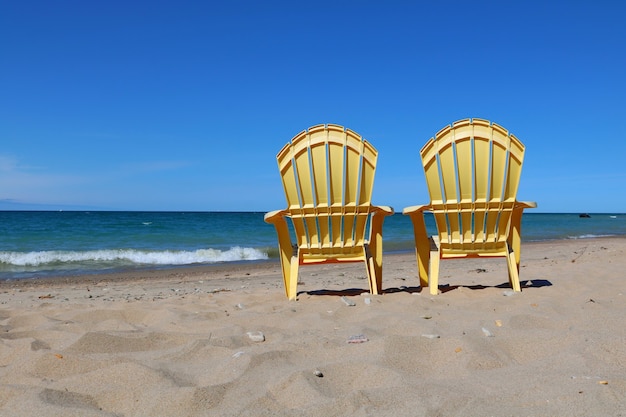 무료 사진 모래 해변에 플라스틱 잔디 의자