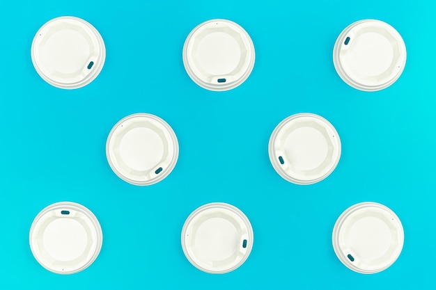 Plastic lids for disposable cups on a blue background flat lay