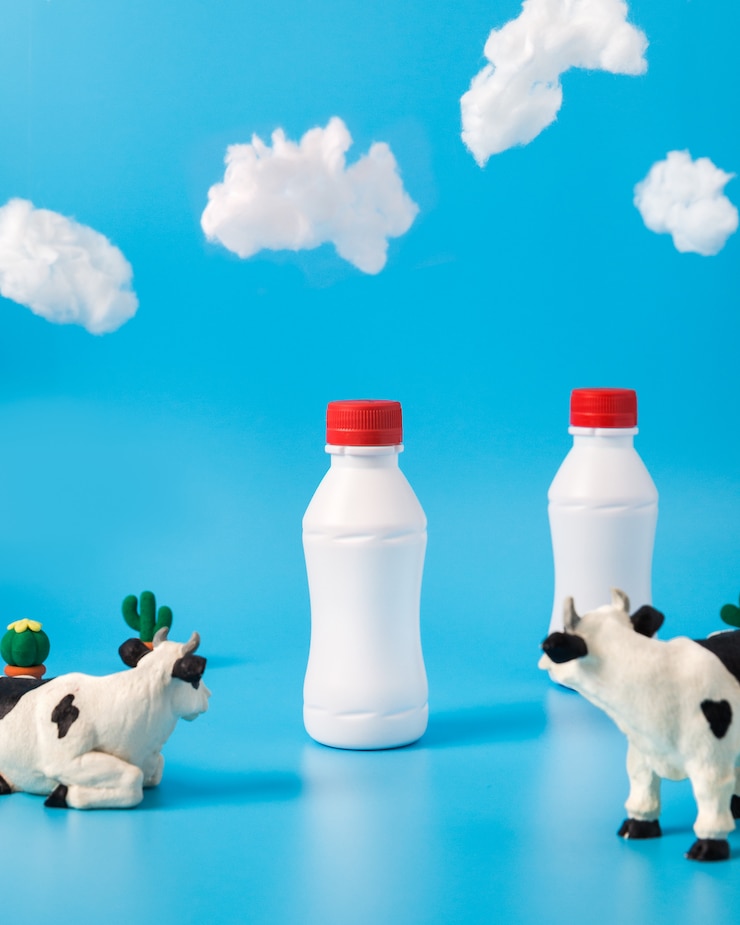 Free Photo plastic milk bottles, toy cows and clouds