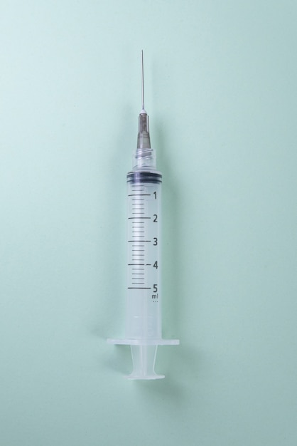 Plastic syringe on green. Top view