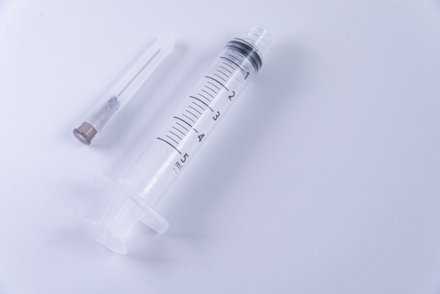 Plastic syringe on the white surface
