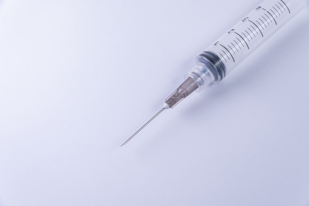Plastic syringe on the white surface