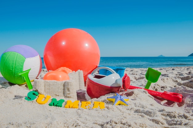 Plastic toys and ball on sand