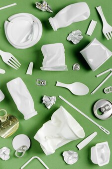 Сбор пластиковых отходов на зеленом фоне. концепция переработки пластика и экологии. плоская планировка, вид сверху