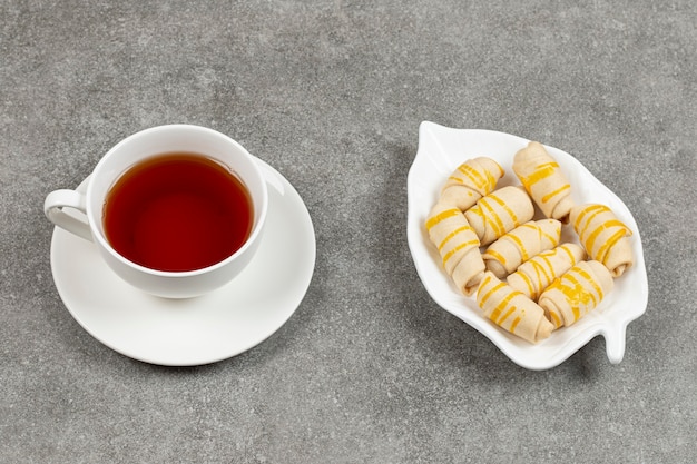 Piatto di biscotti e tazza di tè sulla superficie in marmo