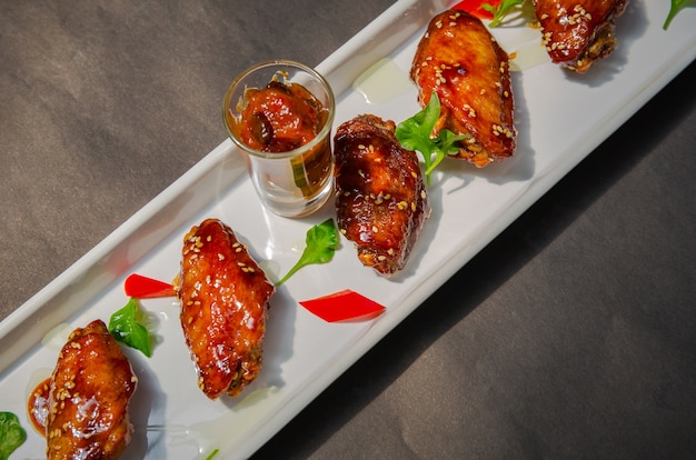 plate of chicken wings on Grunge black background