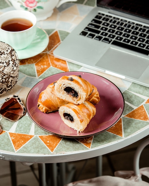 Foto gratuita un piatto di cornetti al cioccolato servito con tè nero