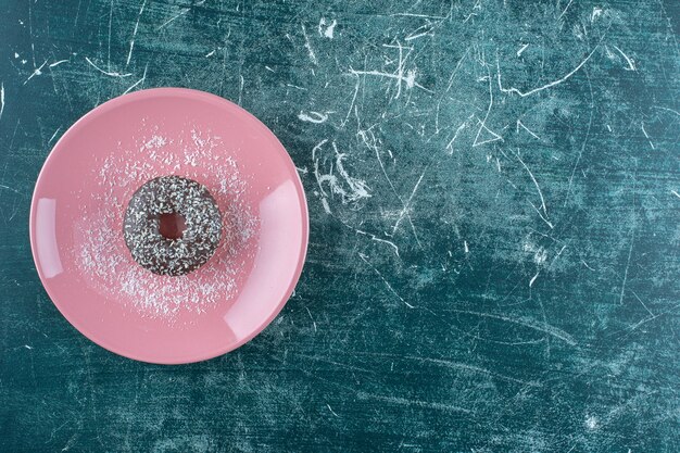 파란색 배경에 초콜릿 도넛 한 접시. 고품질 사진