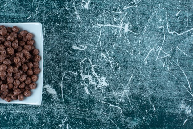 A plate of corn balls on the blue table. 