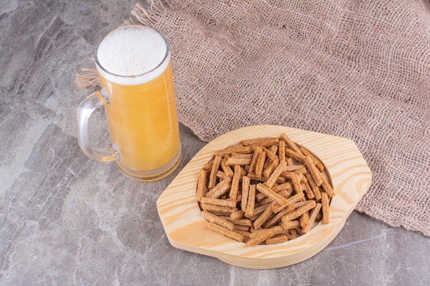 Piatto di cracker con birra sulla superficie di marmo. foto di alta qualità