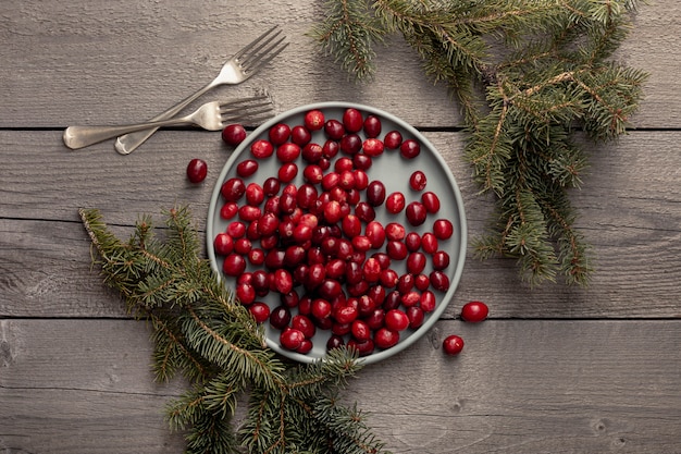 Plate of cranberries with pine and forks