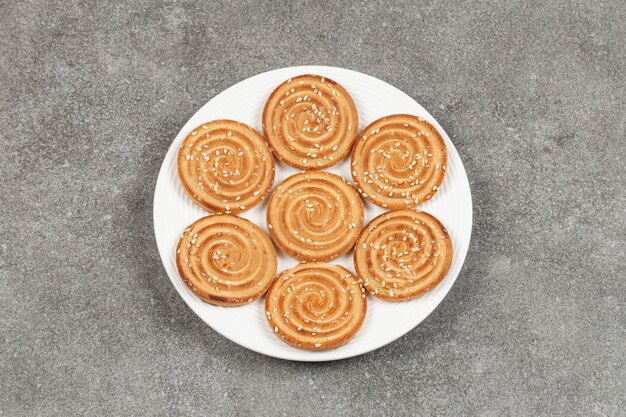Plate of delicious round biscuits on marble surface