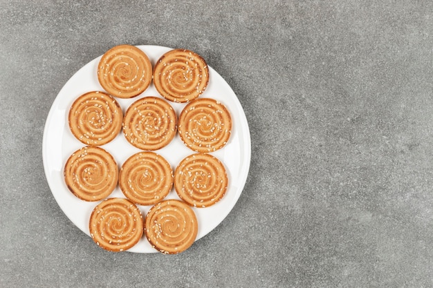 Plate of delicious round biscuits on marble surface