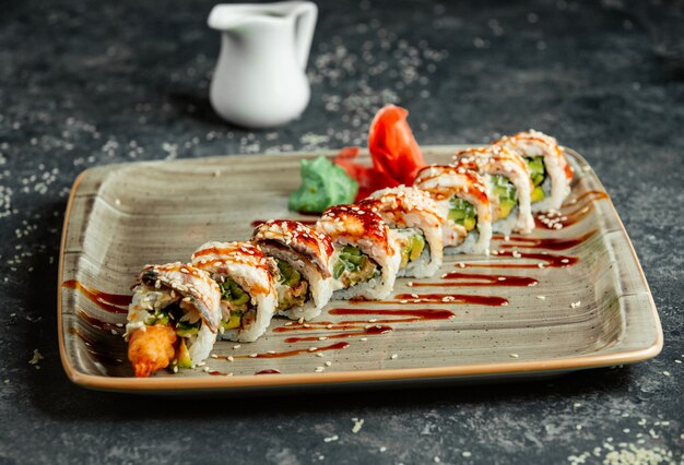 A plate of ebi sushi roll served with wasabi and ginger