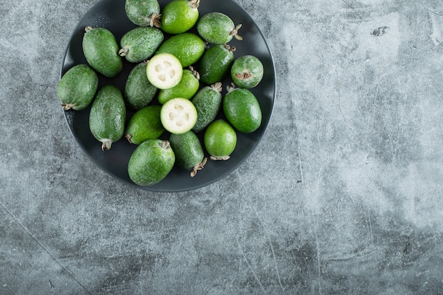 Free photo plate of feijoa fruits on marble background. high quality photo