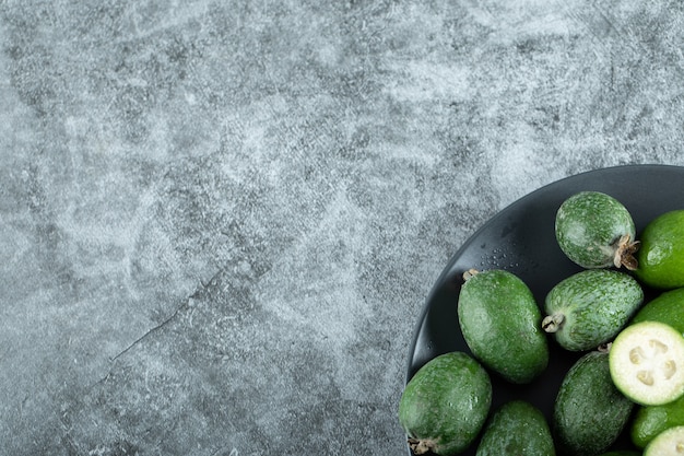 Plate of feijoa fruits on marble.