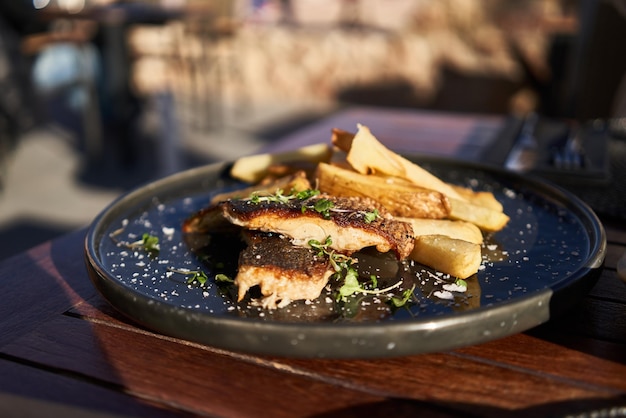 Foto gratuita piatto di patate fish and chips su superficie di legno