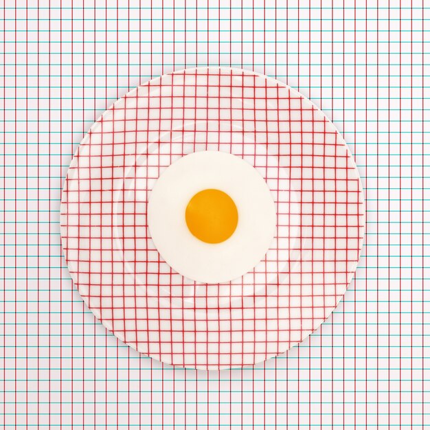 Plate of a fried egg on a table with a geometric pattern