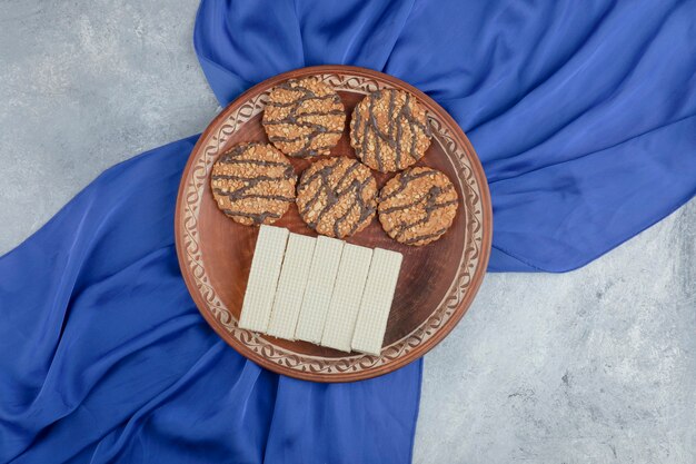 Piatto pieno di biscotti con semi e deliziose cialde su pietra.