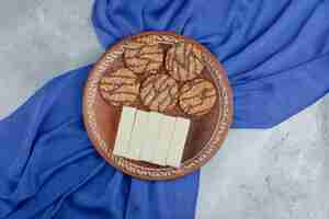 Free photo plate full of cookies with seeds and delicious waffles on stone.