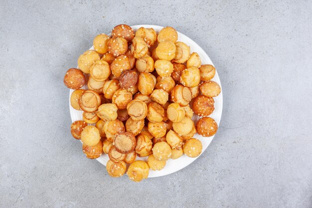 A plate full of small cookies on marble background. High quality photo