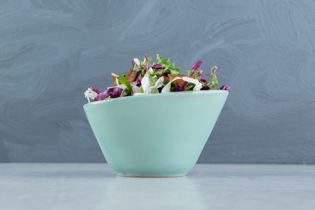 A plate of grated vegetables with lemon , on the marble background.