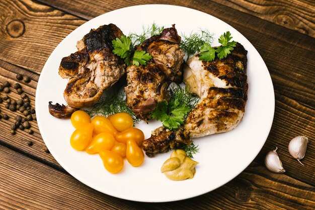 Plate of grilled meat and tomatoes