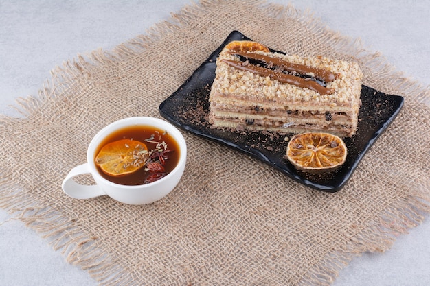 Plate of homemade cake with fruit tea on burlap. High quality photo