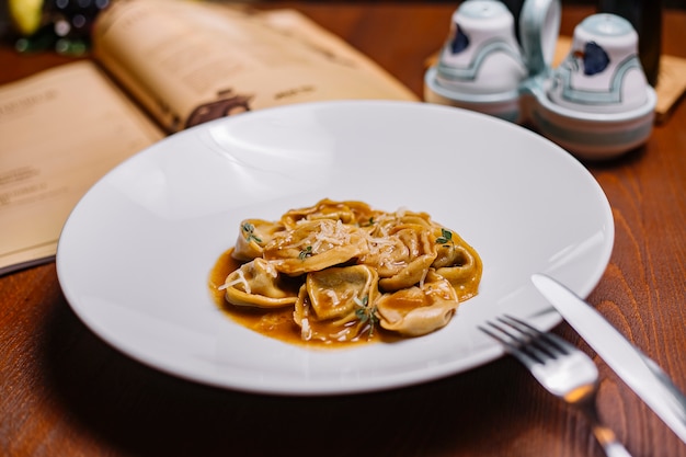 A plate of italian dumpling pasta with sauce garnished with parmesan